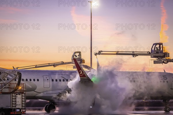 Frost at the airport, a Turkish Airlines aircraft is de-iced in front of sunrise. Airbus A321-231, Fraport, Frankfurt am Main, Hesse, Germany, Europe