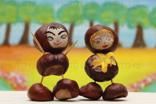 Two cute chestnut figures in front of a painted background, North Rhine-Westphalia, Germany, Europe
