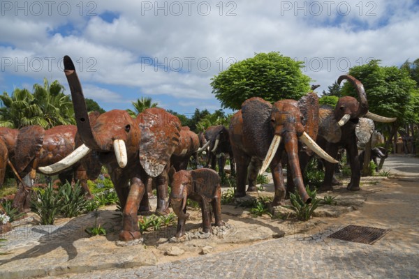 Herd of metal sculptures depicting elephants in a park with trees under a cloudy sky, Bacalhôa, Bacalhoa Buddha Eden, Quinta dos Loridos, largest oriental garden in Europe, Bombarral, Oeste, Centro, Portugal, Europe