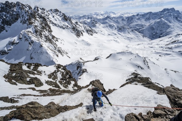 Mountaineer climbing up a steep snow slope, secured by a rope, ascent to the summit of Piz Grialetsch in winter, view of mountain panorama with snow, Grisons Haute Route, Albula Alps, Rhaetian Alps, Grisons, Switzerland, Europe