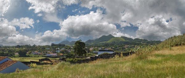 A peaceful rural landscape with houses, hills and volcanic mountains under a partly clear sky, Miradouro do Sertão, Capelas, Sao Miguel Island, Azores, Portugal, Europe