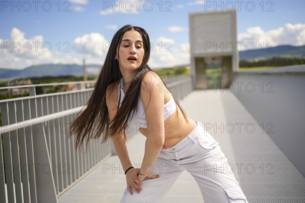 Three quarter length portrait of a caucasian beauty young woman performing urban dance in an outdoor urban bridge
