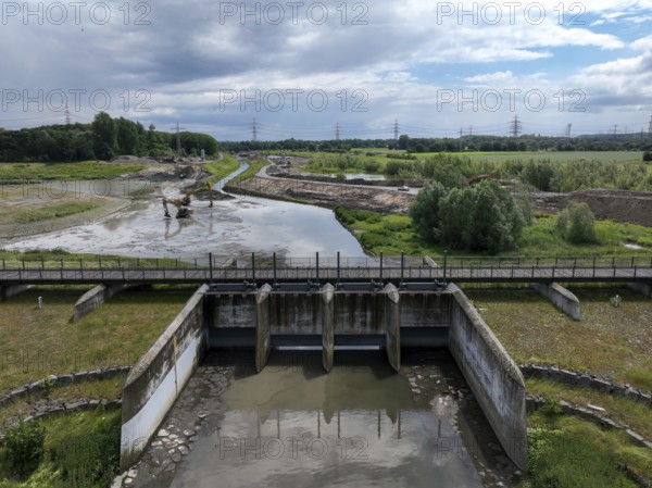Dortmund / Castrop-Rauxel, North Rhine-Westphalia, Germany, river renaturalisation, renaturation of the Emscher, flood retention basin HRB Mengede. A new floodplain landscape is being created at the Emscher-Auen farm, expanding the area for flood protection during heavy rainfall and for biodiversity. The Emscher, which is currently straightened, will be given curves again and can meander through its new floodplain. Following the construction of a parallel sewer, the Emscher has been completely free of wastewater since 2022. The river was previously an open, above-ground mixed water channel with rainwater and wastewater. Here is a view of the Tor tor from the outlet structure, Europe