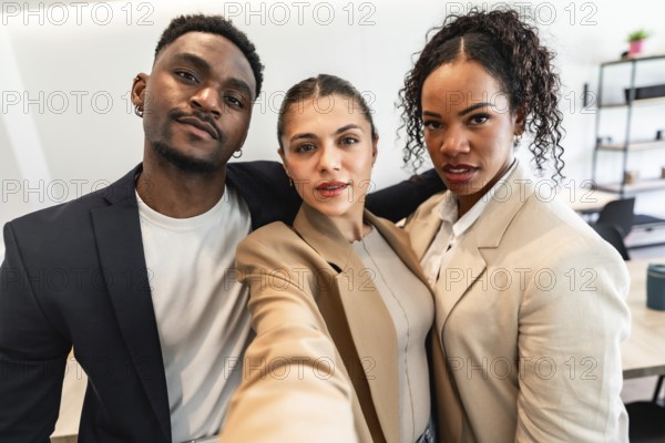 Three diverse business professionals are taking a selfie, showcasing their teamwork and positive office culture
