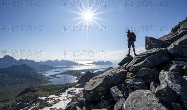 View of mountains and fjord landscape, mountaineer at the summit of Rundfjellet, Sun Star, Austenesfjord fjord, Svolvaer, Nordland, Norway, Europe