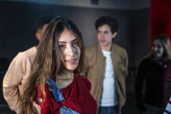 Group of young people enjoying a movie disco dance and event, with a smiling young woman in the foreground