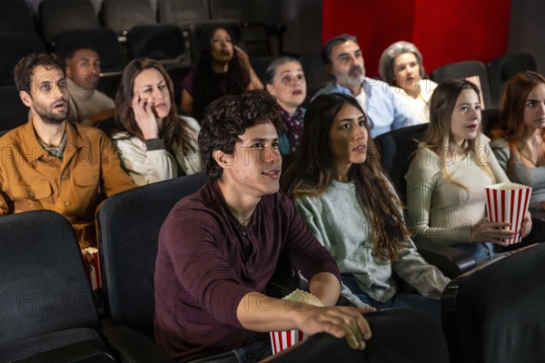 Captivated audience members of various ages and ethnicities experience a thrilling movie screening in a dark cinema, sharing moments of suspense and excitement