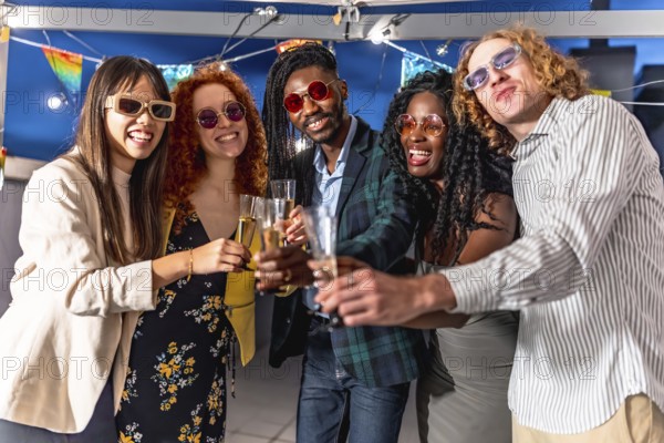 Elegant multiracial friends toasting with champagne together looking at camera at night party in a roof in the city