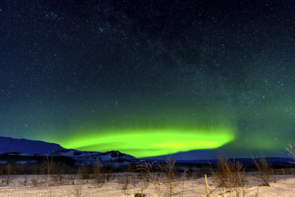 A beautiful Northern Lights in the cold Icelandic winter at night. Concept of Aurora Borealis on snow