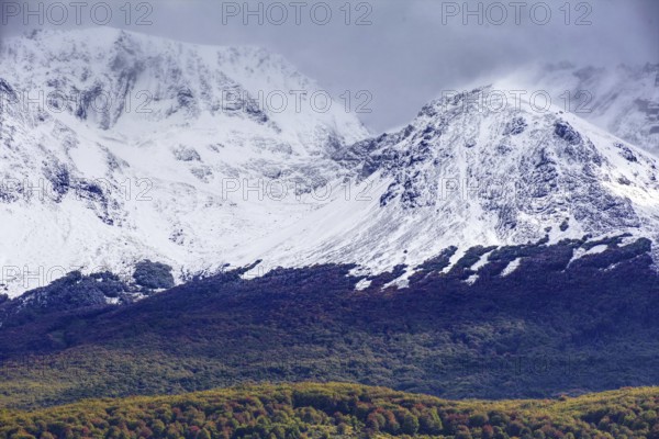 Snow-capped mountains of the Fuegian Andes with a hint of autumn landscape in Ushuaia against an impressive sky, Ushuaia, Argentina, South America