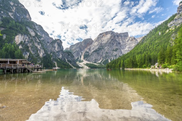 Crystal clear waters reflecting majestic peaks and lush forests create a breathtaking panorama at lake braies, a popular destination in the dolomites