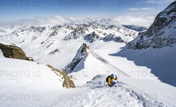 Mountaineer with ice axe and crampons, ascent through steep snowfield to Piz Kesch or Piz d'Es-cha in winter, view of mountain panorama with Vadret da Porchabella glacier, Albula Alps, Rhaetian Alps, Grisons, Eastern Switzerland, Switzerland, Europe