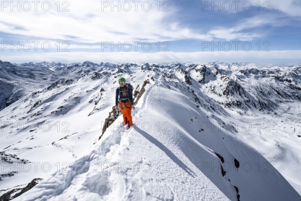 Mountaineer on a narrow mountain ridge in winter, summit of Piz Grialetsch, view of mountain panorama with snow, Grisons Haute Route, Albula Alps, Rhaetian Alps, Grisons, Switzerland, Europe