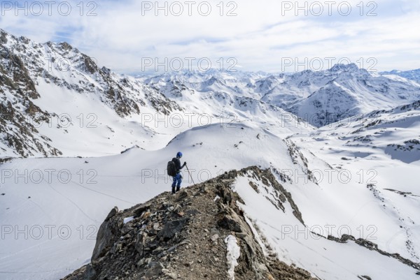 Mountain panorama with view of peaks of the Bernina group, mountaineer descending Piz Grialetsch in winter, Grisons Haute Route, Albula Alps, Rhaetian Alps, Grisons, Switzerland, Europe