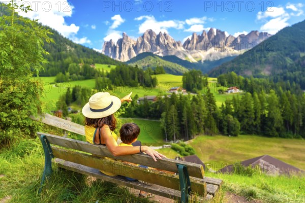 Tourists enjoying breathtaking views of the italian alps in the picturesque val di funes, with the iconic odle mountain range in the background