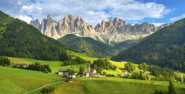 Green meadows, traditional houses, and the iconic santa maddalena church create a picturesque scene with the odle mountains in the background