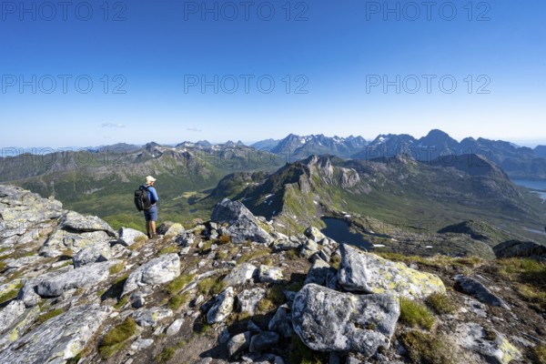 View of mountain landscape, mountain panorama, mountaineer at the summit of Rundfjellet, lake Hellskarvatnet, Svolvaer, Nordland, Norway, Europe