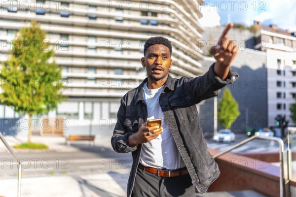 African man pointing to a direction using gps mobile app in the city