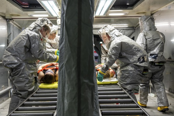 Decontamination of injured persons after an assumed accident involving hazardous substances, fire brigade and aid organisations practise setting up and operating a decontamination station, injured persons are sighted and then washed in a special shower tent to remove possible hazardous substances and chemicals in order to avoid further injuries, the emergency services wear special, ventilated protective suits, large-scale exercise by the Essen fire brigade