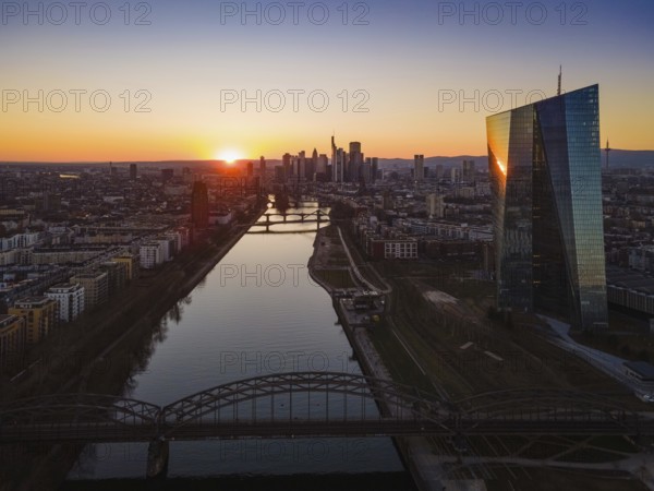 The sun sets behind the European Central Bank (ECB) and the Frankfurt skyline. (Aerial view with a drone), Osthafen, Frankfurt am Main, Hesse, Germany, Europe