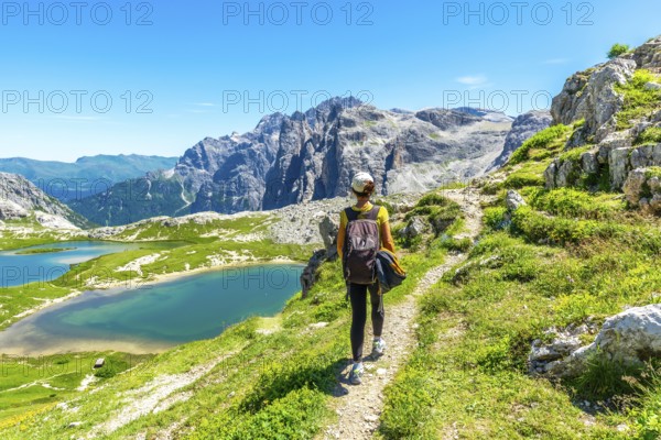 Tourist enjoying the scenic view of the tre cime di lavaredo and alpine lakes in the italian dolomites during summer. Laghi dei Piani