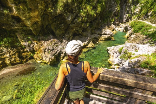 Woman admiring the clear water of tolmin gorges in slovenia, a popular tourist destination in europe