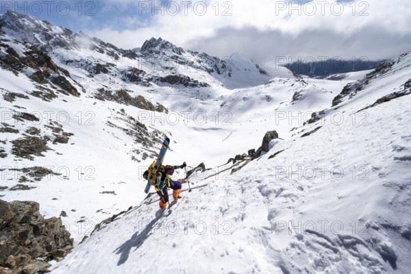 Mountaineer with skis climbing up a steep snow slope to the fork Porta d'Es-cha, ski tour Bündner Haute Route, Albula Alps, Rhaetian Alps, Grisons, Eastern Switzerland, Switzerland, Europe