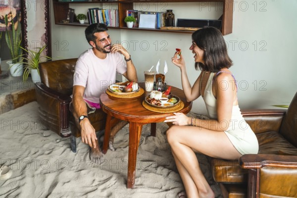 Tourists enjoying breakfast in a restaurant with sandy floor in siargao island, philippines, during summer holidays