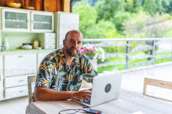 Digital nomad working on laptop in a mountain chalet, enjoying the freedom of remote work and a nomadic lifestyle