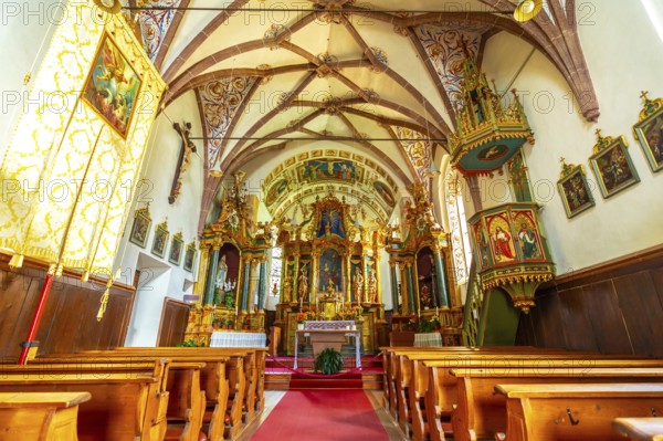 Featuring a richly decorated altar, vibrant frescoes, and a traditional wooden pulpit, the interior of st. Magdalena church captivates in val di funes, italy