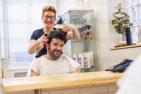 Reflection on the mirror of a cool hairdresser and man with new capillary prosthesis in the salon