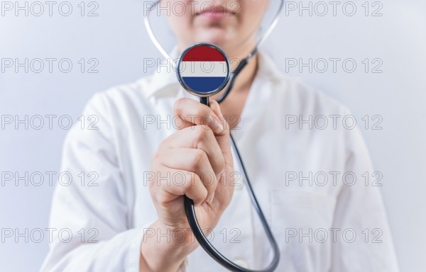 Female doctor holding stethoscope with Dutch flag. National health system of Netherlands