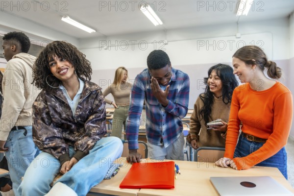 Cheerful multi ethnic university students enjoying time together, laughing and studying in a classroom