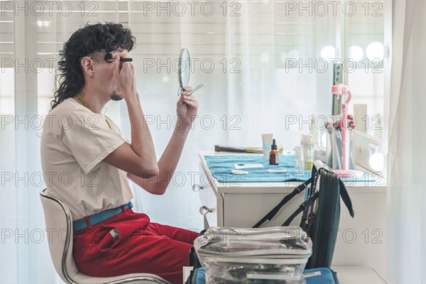 Young make-up artist applying eyebrow pencil while looking in a mirror and getting ready for a performance, showcasing diversity and inclusion in the beauty industry