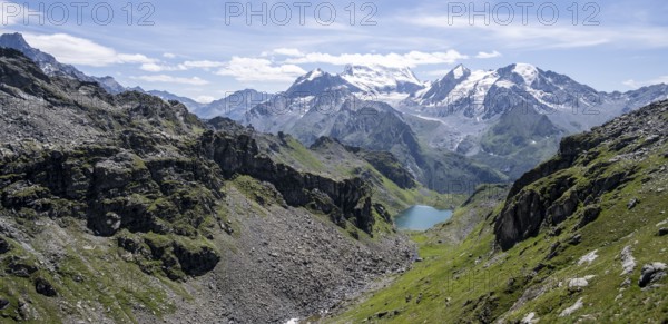 Mountain stream and mountain lake Lac de Louvie with glaciated summit of the Grand Combin, Val de Bagnes, Valais, Switzerland, Europe