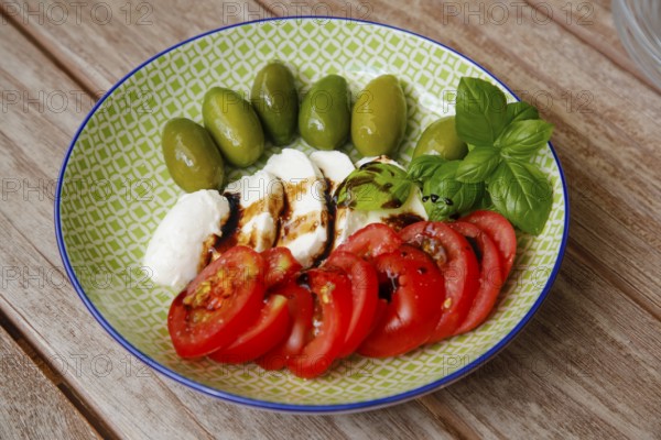 Mediterranean cuisine, cocktail tomatoes, green olives, buffalo mozzarella arranged on a plate, cherry tomatoes, cherry tomatoes, balsamic vinegar, vinegar, basil, healthy cuisine, vegetarian, food photography, studio, Germany, Europe