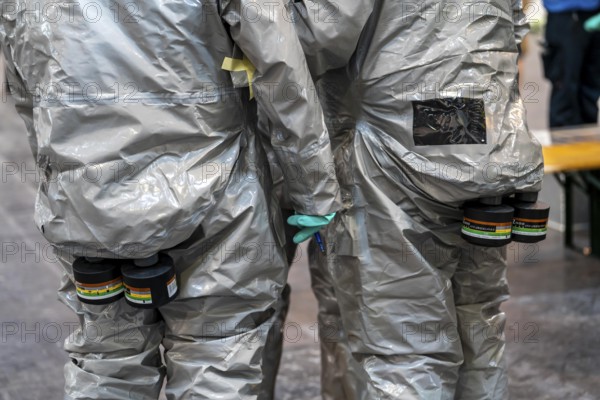 Decontamination of injured persons after an assumed accident involving hazardous substances, fire brigade and aid organisations practise setting up and operating a decontamination station, injured persons are sighted and then washed in a special shower tent to remove possible hazardous substances and chemicals in order to avoid further injuries, the emergency services wear special, ventilated protective suits, large-scale exercise by the Essen fire brigade