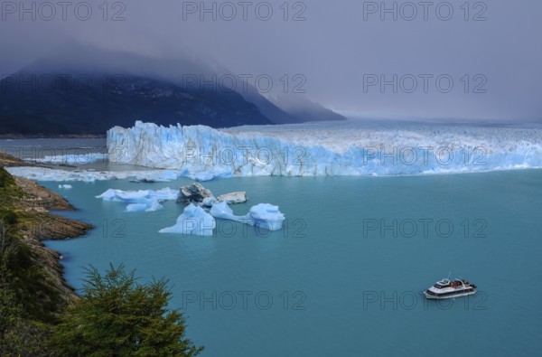 El Calafate, Patagonia, Argentina, Perito Moreno Glacier in Los Glaciares National Park. The Perito Moreno Glacier is part of the Patagonian ice field, the Campo Hielo Sur, the third largest freshwater reserve in the world. It is located in the province of Santa Cruz on Lago Argentino, the country's largest lake. The Perito Moreno Glacier is up to 30 kilometres long and 5 kilometres wide. Its edge is 70 metres high at its highest point. Small icebergs that have broken off from the glacier float in Lago Argentino. The glacier is one of the most beautiful sights in South America and is one of the most visited attractions in Argentina. Tourists can take an excursion boat to the glacier, South America