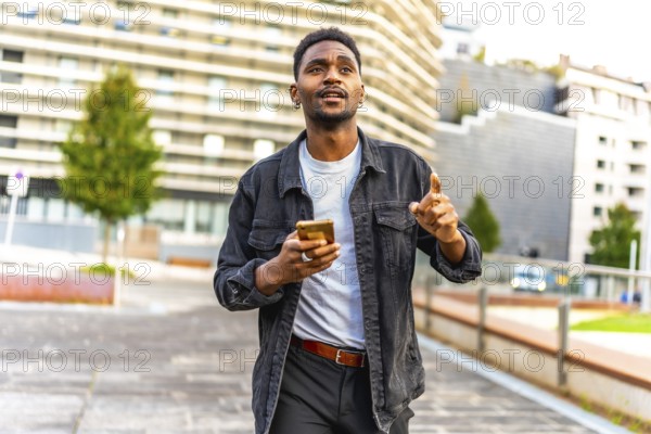 African man walking along the city using gps app to find a direction