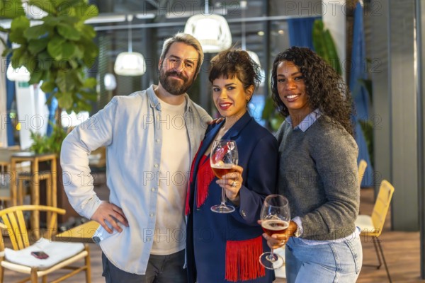 Portrait of happy friends holding beer glasses and smiling at camera during night party outdoors