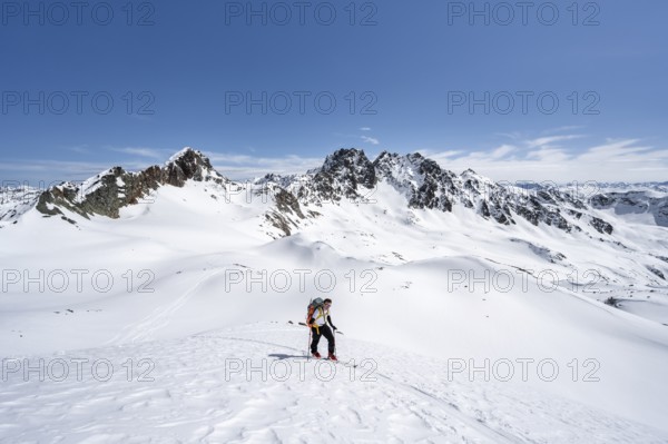 Ski tourer in mountain landscape with snow, view of summits Piz Grialetsch and Piz Vadret, ascent to Scalettahorn, Grisons Haute Route, Albula Alps, Rhaetian Alps, Grisons, Switzerland, Europe