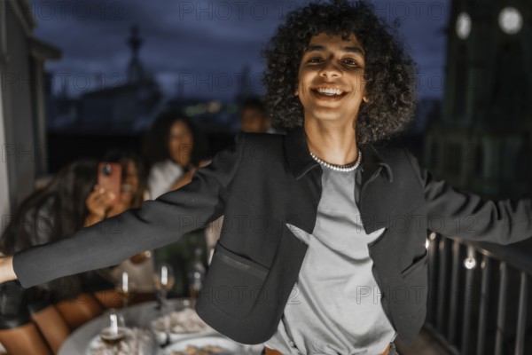 Man dancing happily during night party in a rooftop with multiracial friends