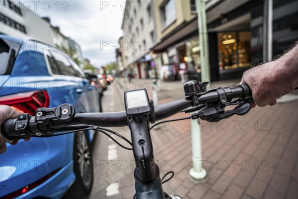 Cycling in the city, inner-city street, cycle lane, bicycles have priority, two-lane traffic with parked cars on both sides, cyclists' perspective, Essen, North Rhine-Westphalia, Germany, Europe