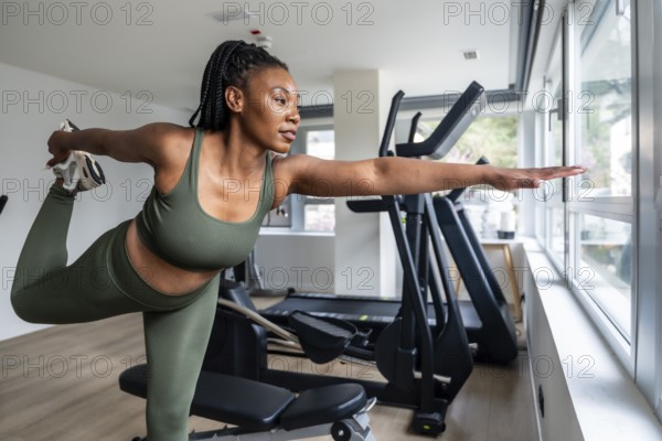 Manager stretching legs in hotel fitness room during business trip, maintaining healthy lifestyle while traveling