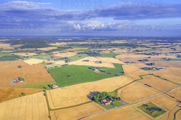 Aerial view over agricultural wheat fields, meadows, farmland and farms in Skåne län, Scania County, southernmost province of Sweden, Scandinavia