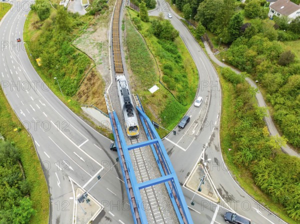 Railway train crosses a bridge with roads and vehicles, track construction, rail delivery for Hermann Hessebahn, Calw, Black Forest, Germany, Europe
