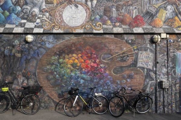 Bicycles in front of a house wall with large-format graffiti of a colour palette, Sølvgades Skole, Copenhagen, Denmark, Europe