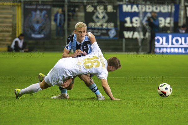 Football 3rd division, season 2024/25, matchday 12: Waldhof Mannheim vs SV Wehen-Wiesbaden. Picture: Fabian Greilinger (18, Wehen-Wiesbaden) and Janne Sietan (22, Mannheim)