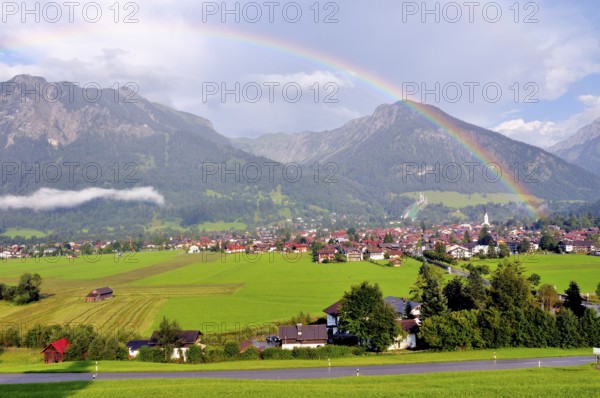 View over Oberstdorf with rainbow, behind it the Schattenberg with Schattenbergschanze, Oberallgäu, Bavaria, Germany, Europe
