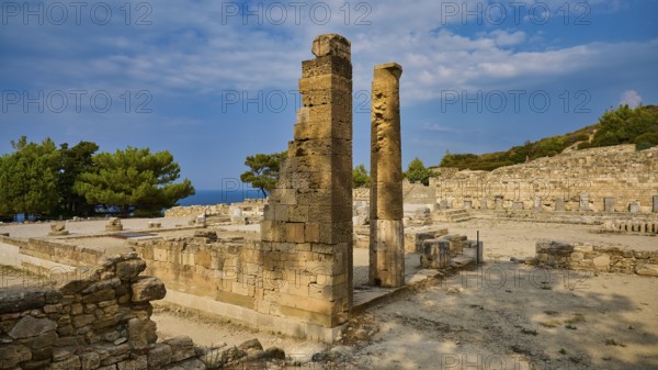 Two ancient stone columns stand in the middle of a ruined site under a slightly cloudy sky, Kamiros, Archaeological site, Ancient city, Foundation of Doric Greeks, Rhodes, Dodecanese, Greek Islands, Greece, Europe